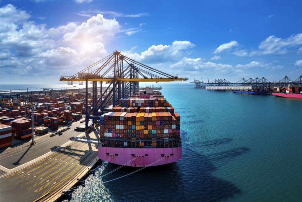 Image of a loaded cargo ship in a busy port on a sunny day